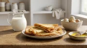 Une belle pile de crêpes fines, garnies de fruits rouges et de sucre glace.