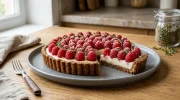 Une part de tarte aux framboises fraîches avec un crémeux au thym sur une pâte sablée croustillante au sucre muscovado.